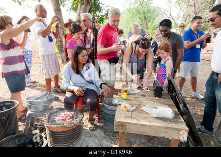 Test de dégustation sont touristiques un vendeur de vendre des rats femelles au barbecue sur une route dans le Nord de la Thaïlande comme snack food Banque D'Images