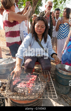 Tourist sont savoureux à partir d'un vendeur de vendre des rats femelles au barbecue sur une route dans le Nord de la Thaïlande comme snack food Banque D'Images