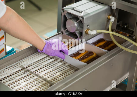 Éclairs au chocolat dans des boîtes. Banque D'Images