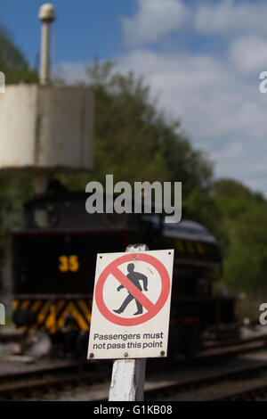 Locomotive à vapeur se tient derrière un avis d'interdiction mise en garde contre l'intrusion de fer à Bolton Abbey. Banque D'Images