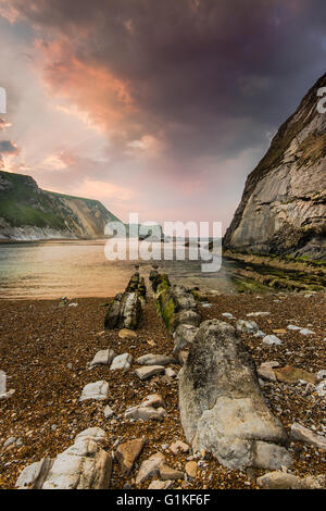 Les nuages au-dessus de spectaculaire rocher sur la plage, dans le Dorset, Man o War Cove Banque D'Images