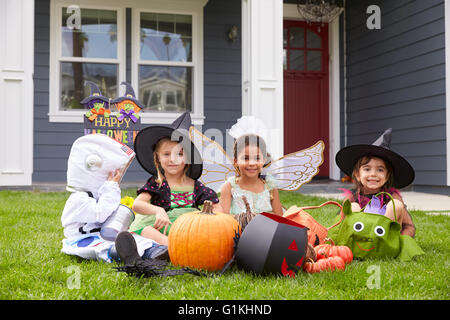 Les enfants vêtus de costumes Tour ou traitement sur le gazon Banque D'Images