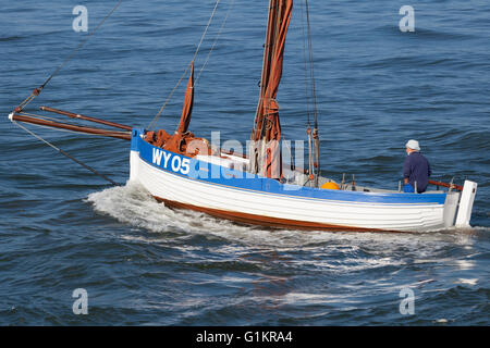 Un bateau de mettre les voiles pour la mer du nord de Whitby Harbour. Banque D'Images