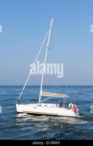 Un bateau de mettre les voiles pour la mer du nord de Whitby Harbour. Banque D'Images