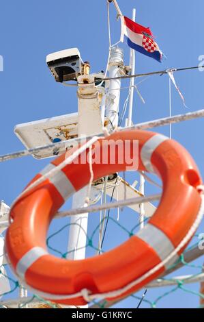 Bouée Orange suspendue sur le bateau blanc avec drapeau croate Banque D'Images