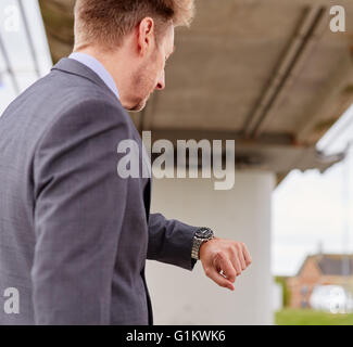 L'homme regardant sa montre se précipiter au travail Banque D'Images