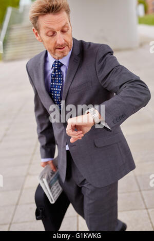 L'homme regardant sa montre se précipiter au travail Banque D'Images