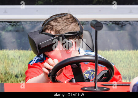Un garçon utilise un oculus Rift sur un simulateur de conduite du tracteur Banque D'Images