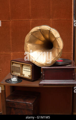 Gramophone ancien avec corne d'or et la radio sur la table sur vintage brown wall background Banque D'Images