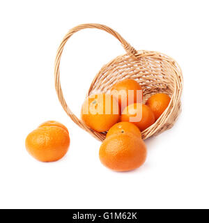 Panier en osier rempli de plusieurs frais mûrs juteux tangerines, isolé sur la composition fond blanc Banque D'Images