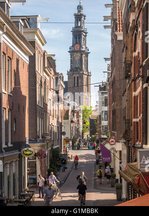 Amsterdam Jordaan. Rues et pont dans le quartier du Jordaan, avec les cyclistes à vélo dans le soleil. Westertoren en arrière-plan. Banque D'Images