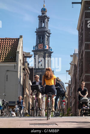 Amsterdam Jordaan. Pont et rue dans le quartier du Jordaan, avec les cyclistes à vélo dans le soleil. Westertoren en arrière-plan. Banque D'Images