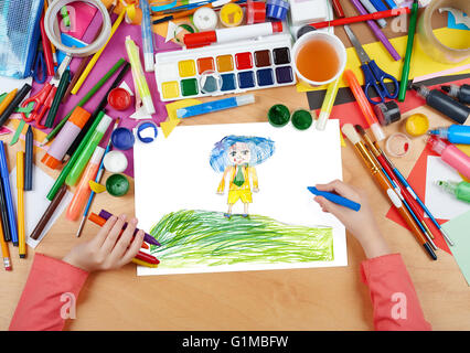 Garçon avec chapeau bleu sur top meadow hill enfant dessin, vue d'en haut les mains avec de la peinture au crayon sur papier photo d'art, lieu de travail Banque D'Images