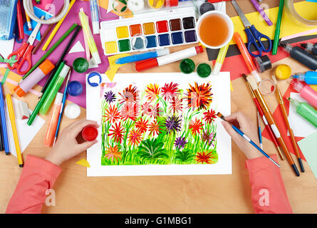 Lit fleur gros plan pré arrière-plan, dessin de l'enfant, vue d'en haut les mains avec de la peinture au crayon sur papier photo d'art, lieu de travail Banque D'Images