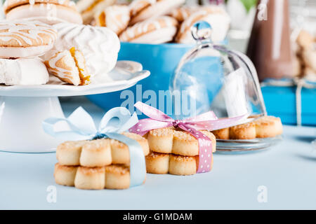 Les cookies, des milkshakes, bocal de bonbons, fleurs et cadeaux en bleu et rose Banque D'Images