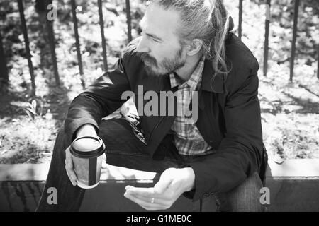 Homme asiatique barbu avec le café tasse de papier, extérieur noir et blanc portrait avec selective focus Banque D'Images