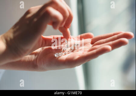 En boucles d'une femelle palm. Femme mariée, va lancer sur boucles d'oreille. Banque D'Images