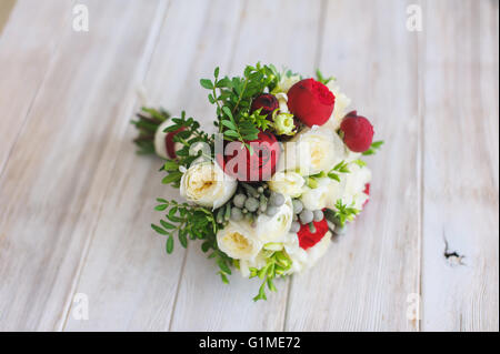 Belle et coloré bouquet de fleurs de mariage plus de table en bois. Fond en bois clair. Roses blanches et rouges. Style rustique. Banque D'Images