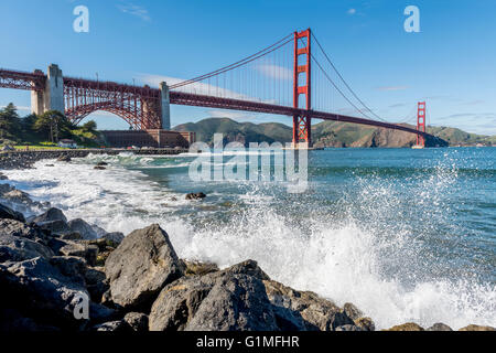 Vagues se brisant sur le rivage de la baie de San Francisco, avec le Golden Gate Bridge en arrière-plan. La Californie, USA Banque D'Images