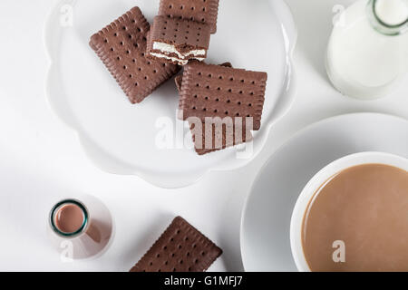 Tasse de café et quelques bouteilles de lait et chocolat lait frappé sur fond blanc du haut Banque D'Images