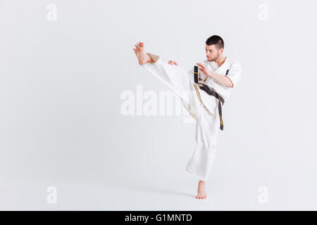 L'homme en kimono combats isolé sur fond blanc Banque D'Images