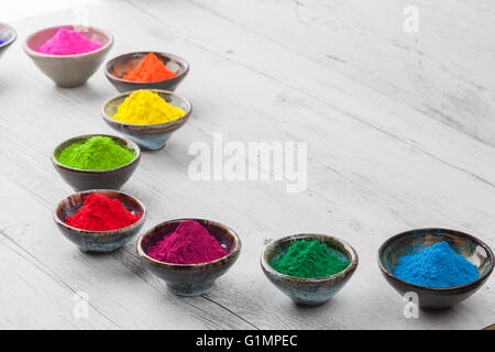 Poudre teint lumineux et colorés en céramique tasses sur la table rustique en bois blanc. Banque D'Images