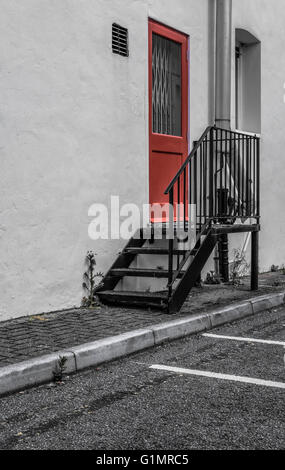 Porte coupe-feu verrouillée vue sur le côté d'une entrée d'usine avec des tuyaux récemment installés visibles. Banque D'Images