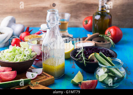 Vinaigrette maison et les ingrédients. Des légumes bio sur table rustique. Les ingrédients pour les salades. La nourriture végétarienne, concept, rustique Banque D'Images