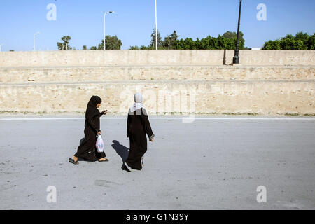 Deux femmes musulmanes en passant par les murs entourant la grande mosquée de Kairouan dans la rue de Kairouan, Tunisie. Banque D'Images