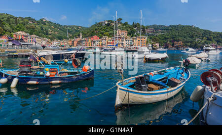 Portofino, Province de Gênes, Ligurie, Riviera Italienne, Italie. Bateaux dans le port avec le village derrière. Banque D'Images