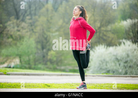 Portrait de femme sportive faisant des exercices d'étirement en position de stationnement avant l'entraînement. Athlète féminin runner étant prêt pour l'exécution Banque D'Images