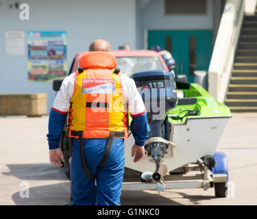 Un pilote suit son bateau de moteur à la rampe de lancement avant une course. Banque D'Images