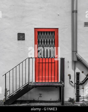 Porte coupe-feu verrouillée vue sur le côté d'une entrée d'usine avec des tuyaux récemment installés visibles. Banque D'Images