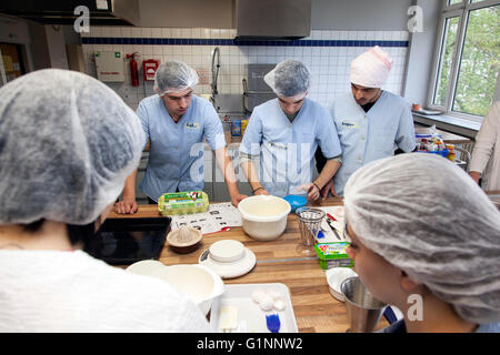 L'école internationale classe apprend comment cuisiner et cuire dans la formation cuisine. Banque D'Images