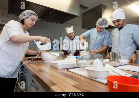 L'école internationale classe apprend comment cuisiner et cuire dans la formation cuisine. Banque D'Images