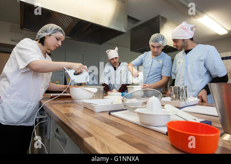 L'école internationale classe apprend comment cuisiner et cuire dans la formation cuisine. Banque D'Images