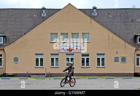 Praha,. 30Th Mar, 2016. Un enfant réfugié le vélo en face de l'abri des réfugiés à Bad Fallingbostel, Allemagne, 30 mars 2016. Environ 850 personnes ont été hébergées ici en mars. PHOTO : HOLGER HOLLEMANN/dpa/Alamy Live News Banque D'Images