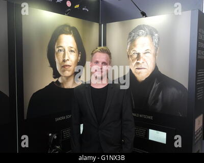 Munich, Allemagne. 3 mai, 2016. Marco photographe Daniel Schoeler debout devant des portraits des acteurs de doublage Sandra Schwittau (connu sous le nom de voix allemande Bart Simpson et Eva Mendes) et Ronald Nitschke (connu sous le nom de la voix de l'Allemand Tommy Lee Jones) à l'exposition 'Les visages derrière les voix' à la gare centrale de Munich, Allemagne, le 3 mai 2016. Portraits des faits Schoeler acteurs de doublage pour de célèbres stars d'Hollywood. PHOTO : BRITTA SCHULTEJANS/dpa/Alamy Live News Banque D'Images