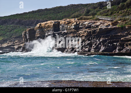 L'Australie, Nouvelle Galles du Sud, Côte Centrale, Bouddi National Park, les vagues se brisant sur un rocher de la côte de la péninsule de Bouddi Banque D'Images