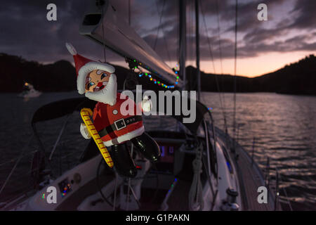 Au crépuscule, les lumières de Noël et un plastique Santa flying de la rampe d'un bateau au mouillage. Noël 2015. Nouvelle Zélande Banque D'Images