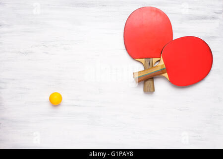 Deux raquettes de tennis de table sur une table en bois blanc. Vue de dessus de raquettes. Concept de la concurrence. Banque D'Images