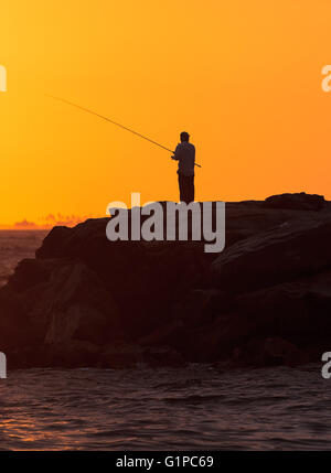 Silhouette d'hommes sur le quai de pêche au large de l'Île de Balboa, Newport Beach au coucher du soleil dans le sud de la Californie Banque D'Images