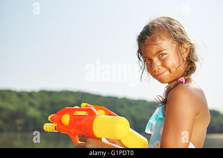 Jeune fille jouant avec un pistolet sur le squirt vacances d Banque D'Images