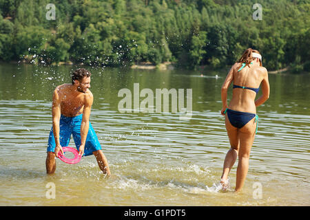 Heureux couple pulvériser de l'eau à l'autre et s'amuser en été Banque D'Images