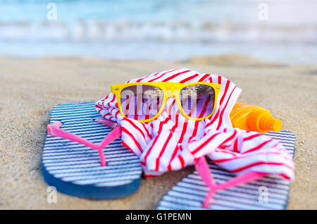 Les choses sont dispersées sur la plage de la mer. Se concentrer sur des verres. Banque D'Images