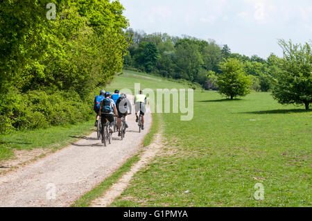 Les cyclistes dans les North Downs Way et passage à niveau du chemin de Colley colline au-dessus de Reigate. Voyageant à l'Est. Banque D'Images