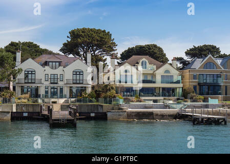 Maisons au bord de l'eau à des bancs de sable, le port de Poole, Dorset, UK Banque D'Images