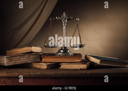 Vieux livres reliés et échelle d'argent sur une table en bois, la justice et la connaissance concept Banque D'Images