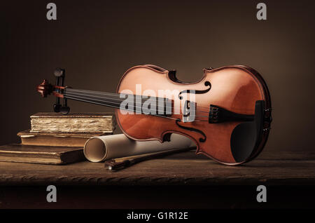 Ancien violon avec rouleaux de feuille de musique et de vieux livres sur une table en bois, still life Banque D'Images
