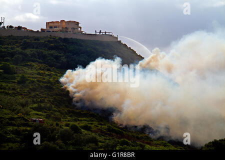 Feu de forêt en Grèce, les pompiers pulvériser de l'eau d'un hôtel sur une colline Banque D'Images